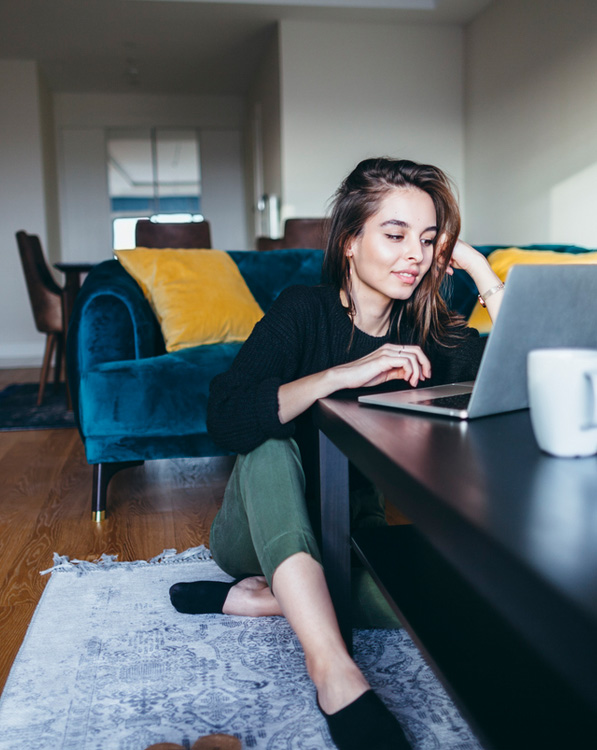 a person sitting at a table using a laptop computer